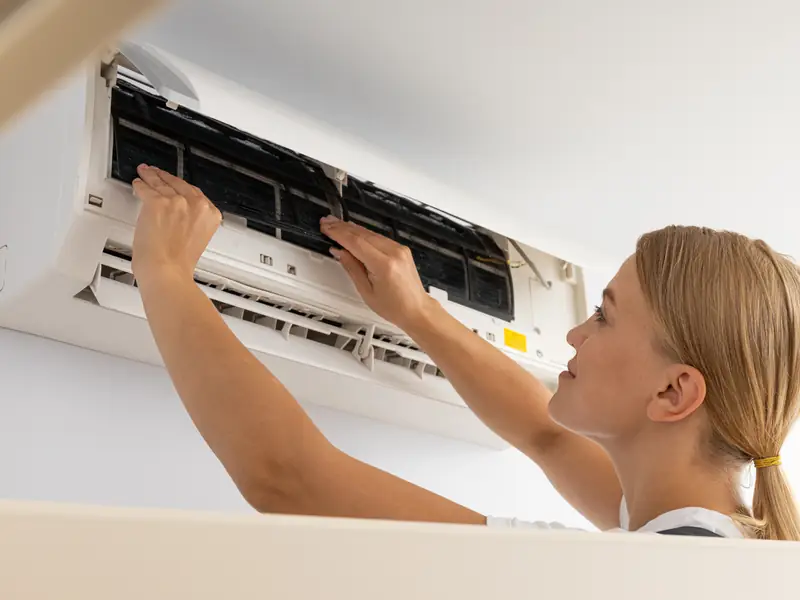 Nettoyage des filtres d'un climatiseur lors d'une visite de maintenance