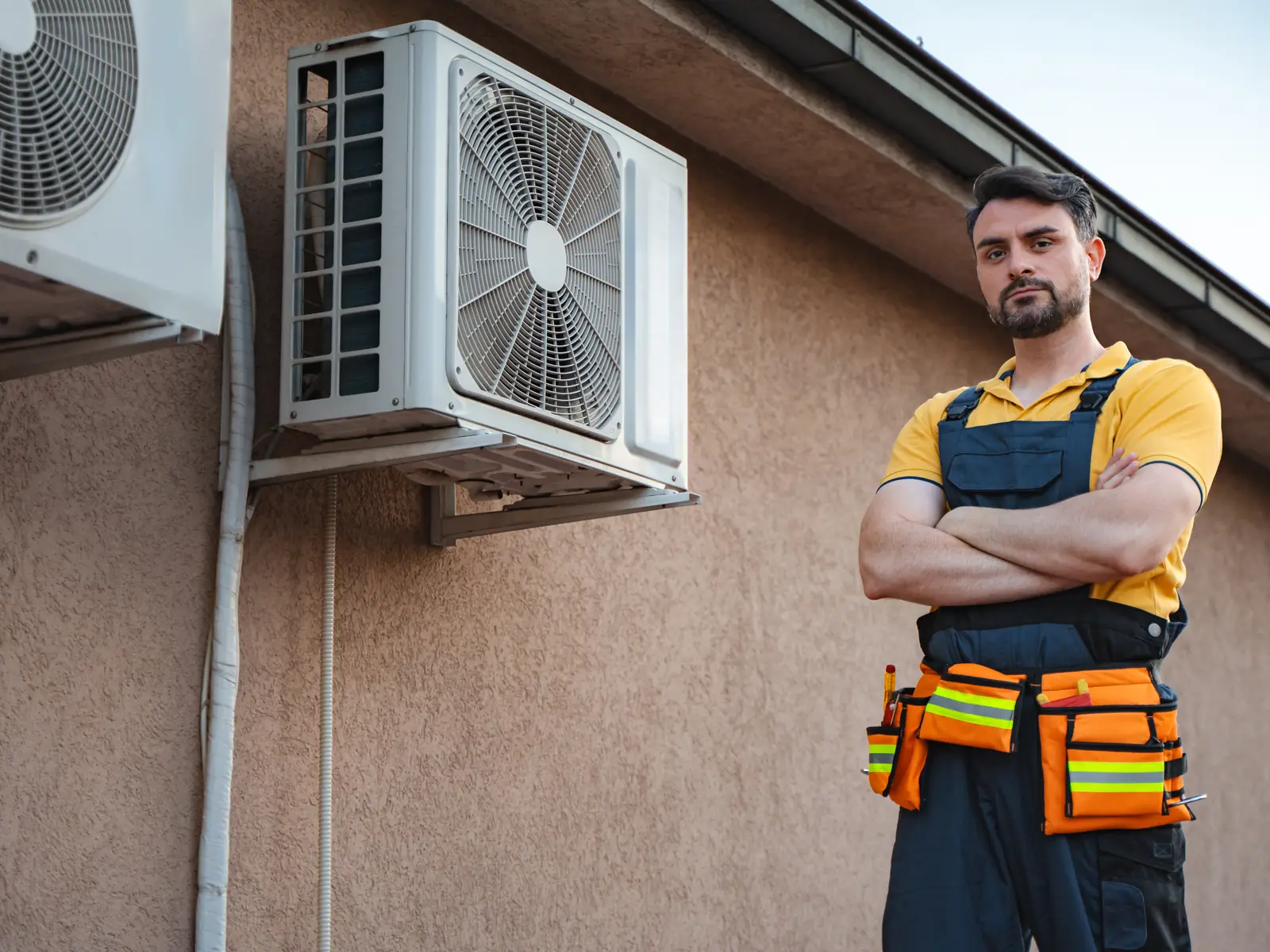 Technicien climaticien devant un groupe extérieur de climatisation à contrôler