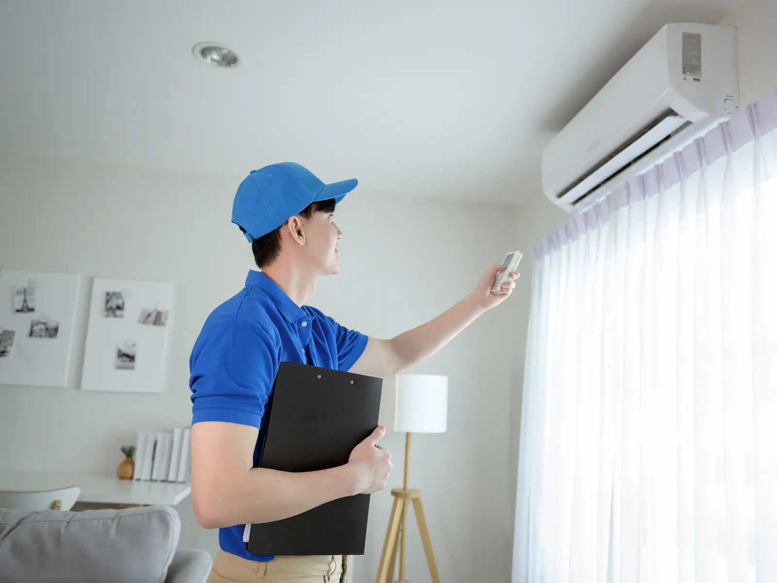 Technicien à côté d'une climatisation murale qu'il vient d'entretenir