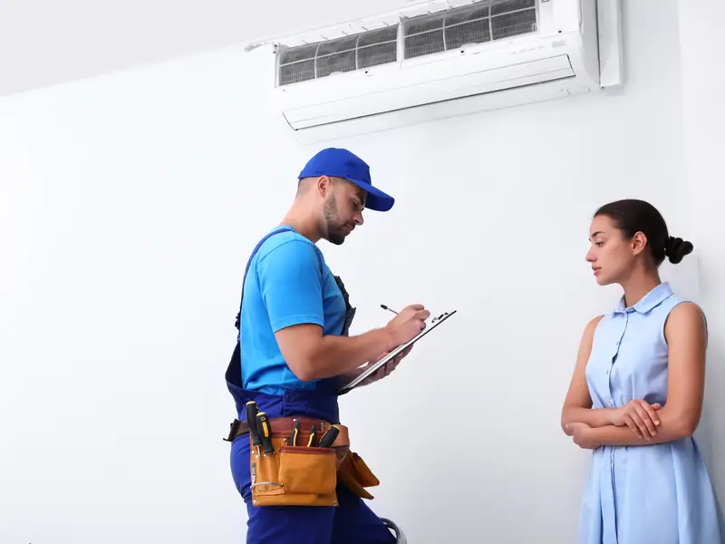 Technicien expliquant à une cliente la panne constatée sur sa climatisation