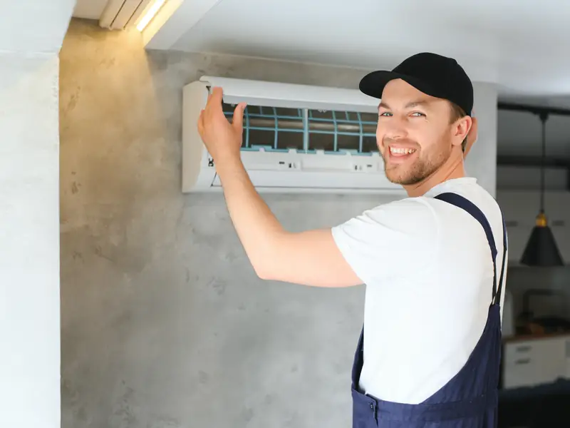 Technicien intervenant sur une climatisation murale en dépannage