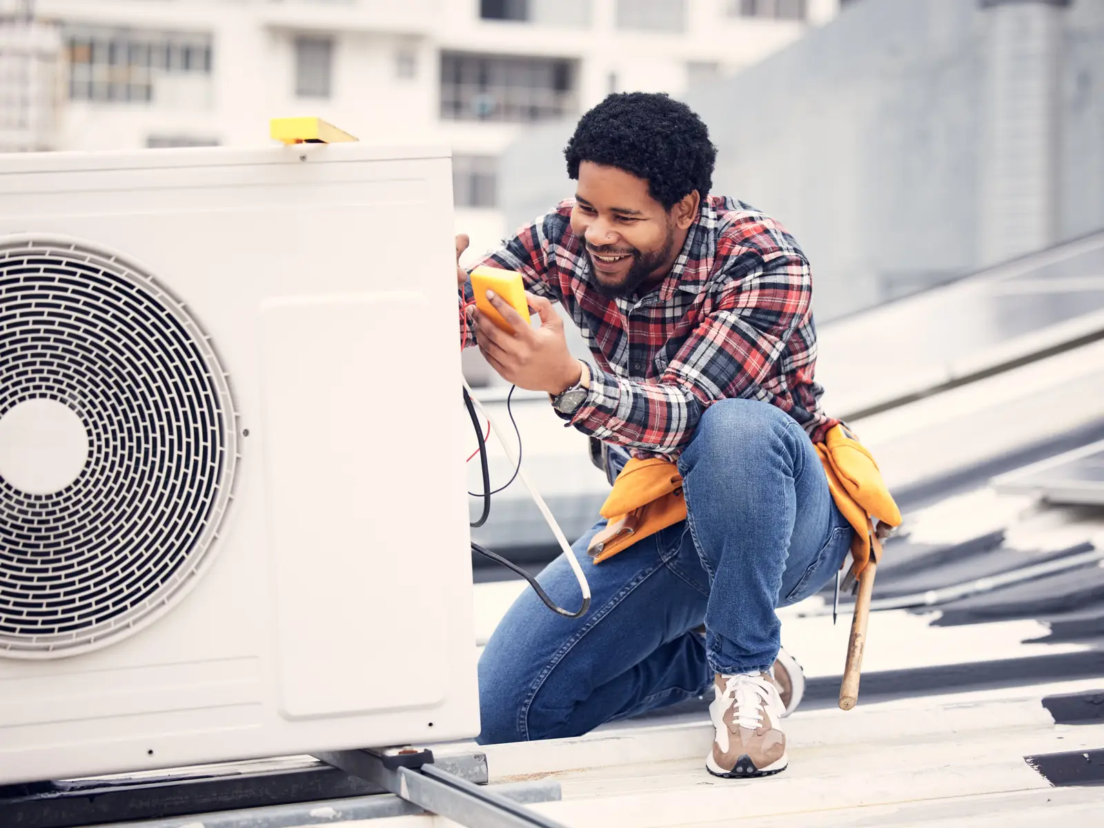 Technicien prenant des mesures électriques sur un groupe extérieur avant la saison chaude